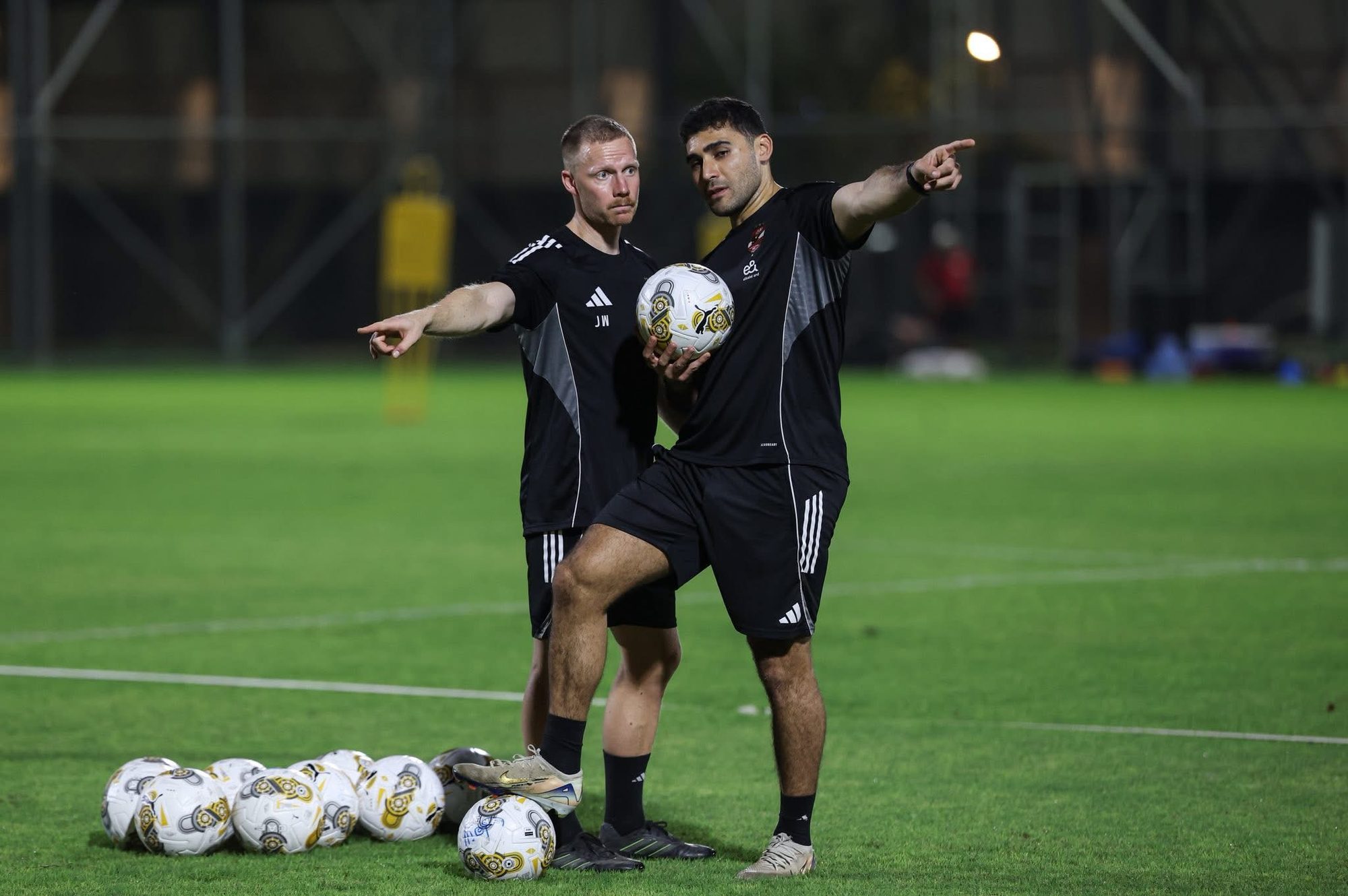 A night session: Shihy and a coach setting up a drill