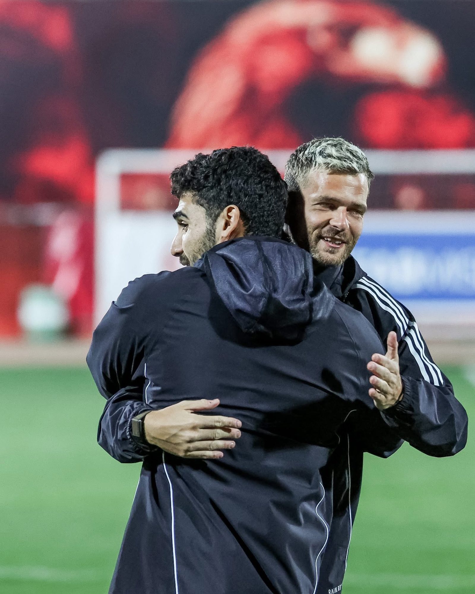 Shihy hugging a colleague on the pitch
